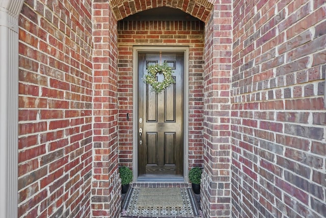 view of exterior entry with brick siding