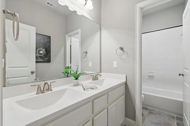 bathroom featuring double vanity, toilet, visible vents, and a sink