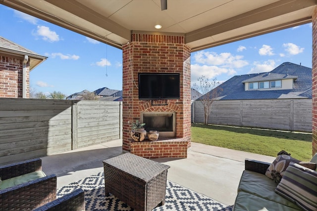 view of patio / terrace featuring an outdoor living space with a fireplace and a fenced backyard