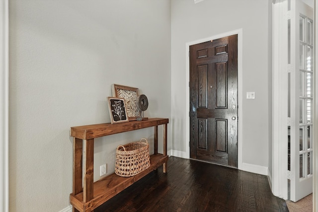 foyer entrance featuring baseboards and wood finished floors