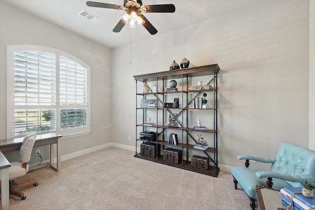 office space with visible vents, carpet floors, baseboards, and a ceiling fan