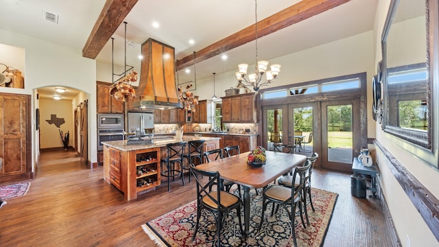 dining space featuring beam ceiling, visible vents, arched walkways, and a towering ceiling