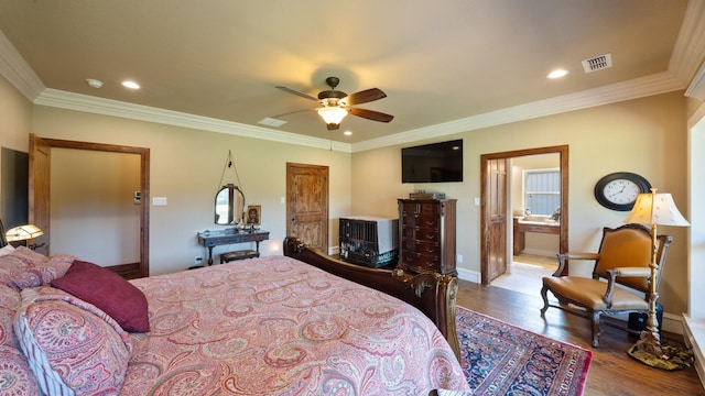 bedroom featuring baseboards, wood finished floors, and crown molding