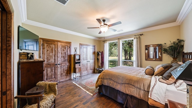 bedroom with crown molding, wood finished floors, visible vents, and ceiling fan