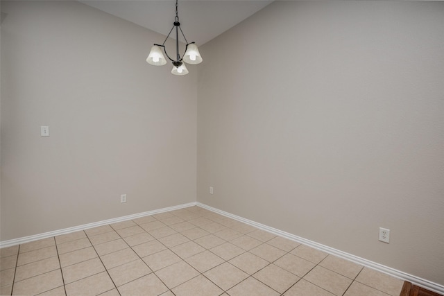 unfurnished room with a notable chandelier and baseboards