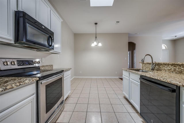 kitchen with black appliances, a sink, white cabinetry, arched walkways, and light tile patterned floors