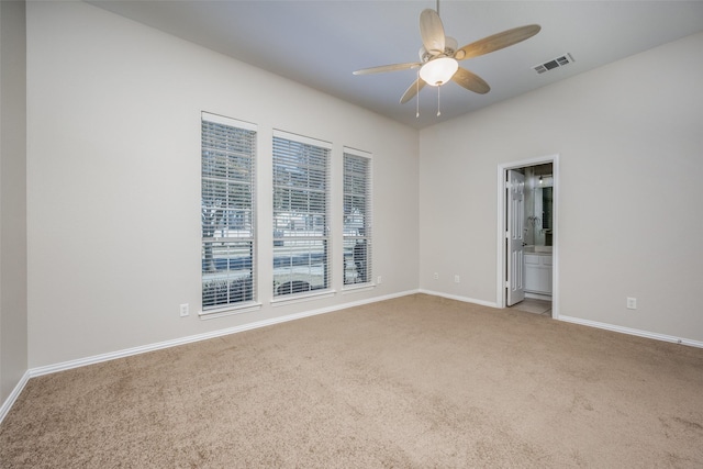 carpeted empty room featuring baseboards, visible vents, and ceiling fan