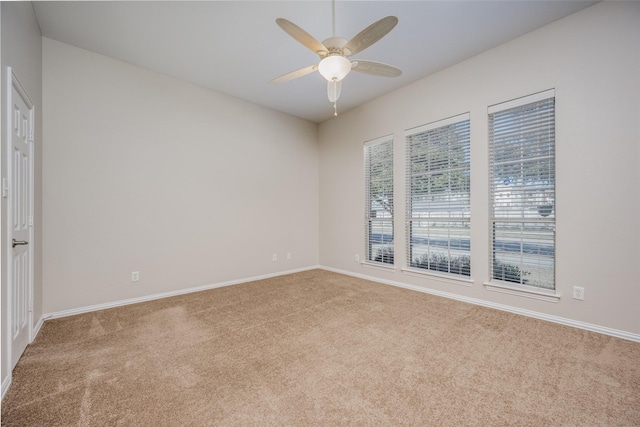 spare room with carpet flooring, a ceiling fan, and baseboards