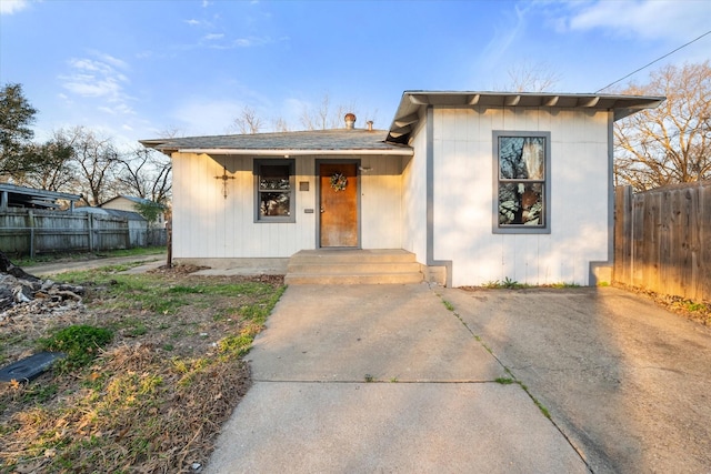 bungalow-style home featuring fence