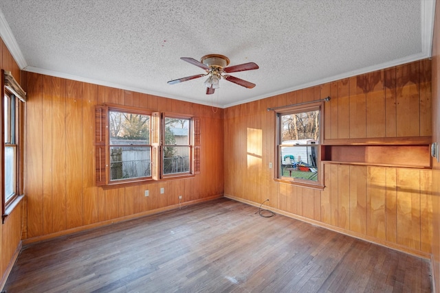 unfurnished room featuring plenty of natural light, a textured ceiling, a ceiling fan, and wood finished floors