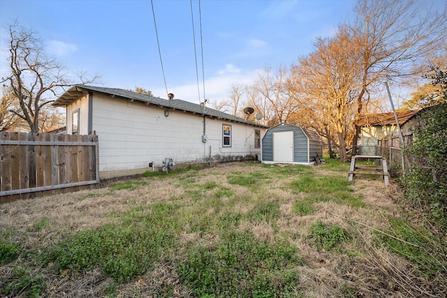 back of house with an outbuilding, a storage shed, and fence