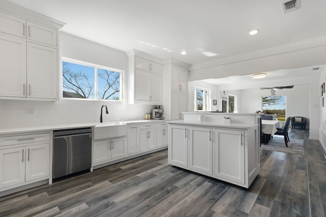 kitchen with visible vents, a kitchen island, a sink, light countertops, and stainless steel dishwasher