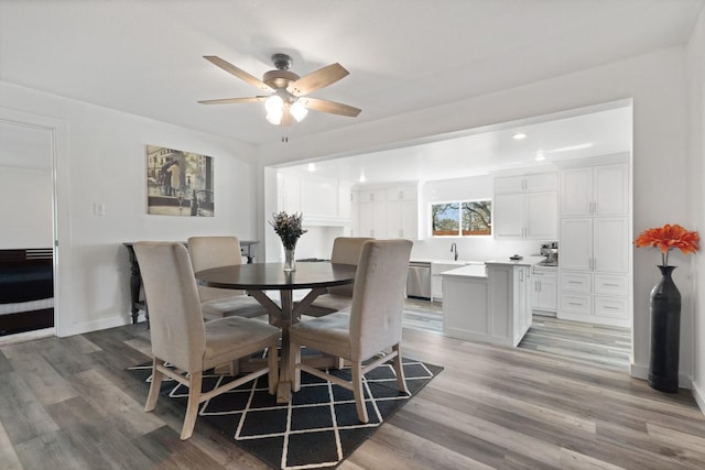 dining room with ceiling fan, baseboards, and light wood-style floors