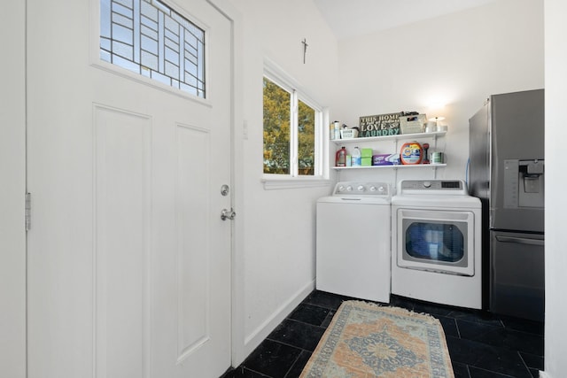 laundry area with washer and dryer, baseboards, dark tile patterned floors, and laundry area