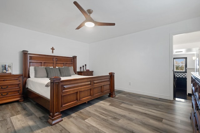 bedroom featuring baseboards, ceiling fan, and wood finished floors