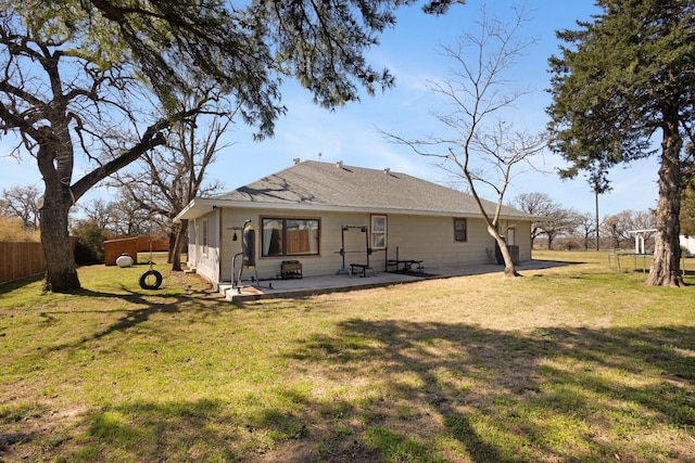 rear view of house featuring a patio, a yard, and fence