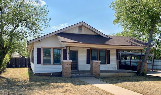 bungalow featuring a porch, a shingled roof, a front yard, and fence