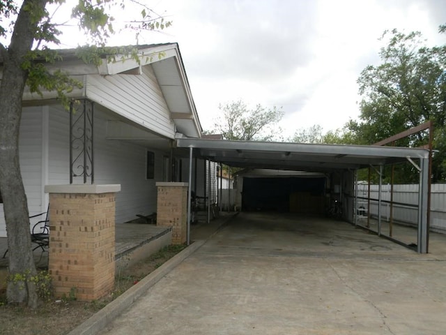 view of home's exterior with an attached carport, driveway, and fence