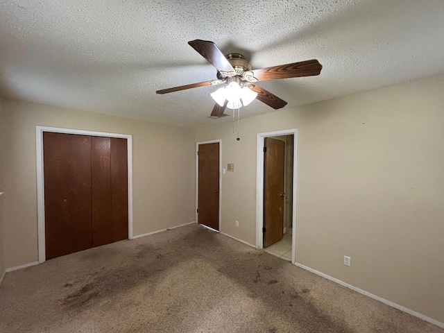 unfurnished bedroom with a ceiling fan, a closet, carpet floors, and a textured ceiling