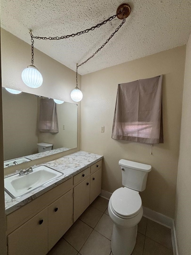 bathroom with vanity, baseboards, lofted ceiling, tile patterned floors, and toilet