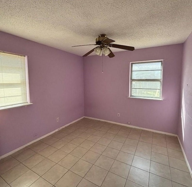 empty room with baseboards, a textured ceiling, and a ceiling fan