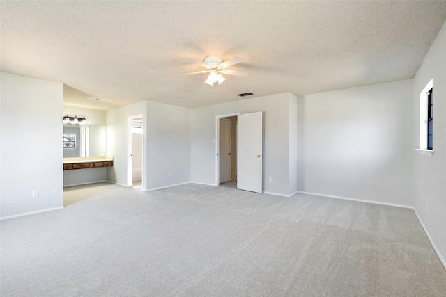 interior space featuring visible vents, baseboards, a textured ceiling, and ceiling fan