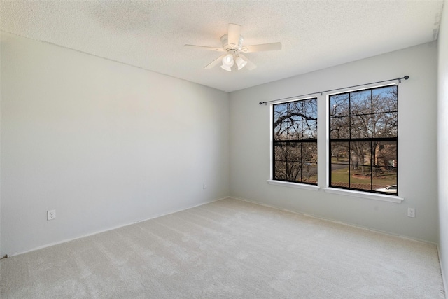 carpeted empty room featuring a textured ceiling and ceiling fan