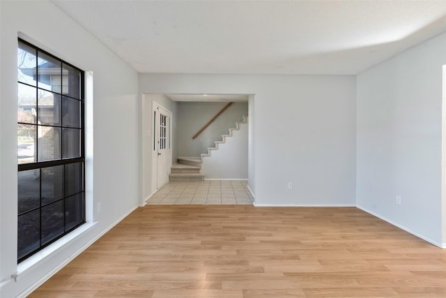 interior space with stairway, baseboards, and light wood-style flooring