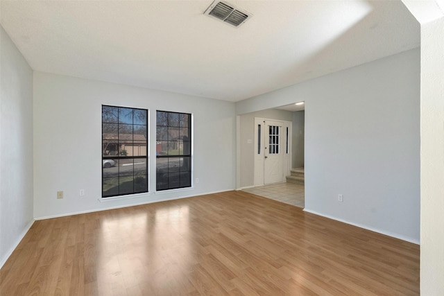 unfurnished room with visible vents, baseboards, and light wood finished floors