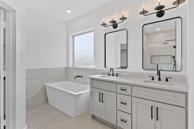 bathroom featuring double vanity, a freestanding tub, a stall shower, and a sink