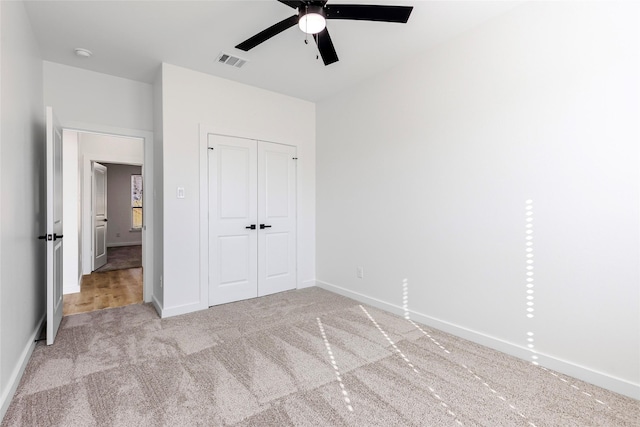 unfurnished bedroom with visible vents, a ceiling fan, a closet, carpet flooring, and baseboards