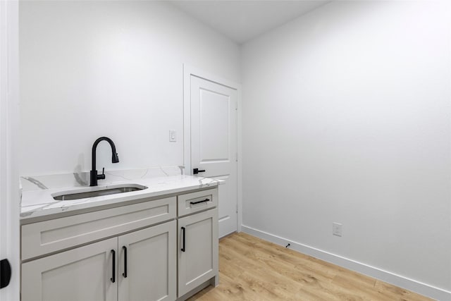 bathroom featuring vanity, wood finished floors, and baseboards