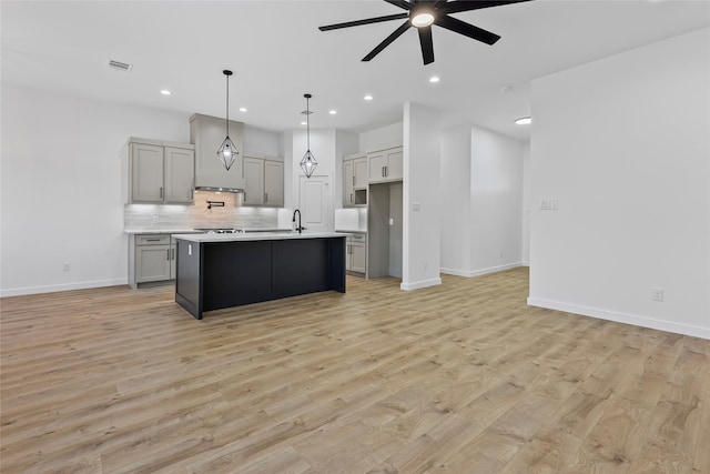 kitchen with light wood-type flooring, visible vents, a ceiling fan, open floor plan, and light countertops