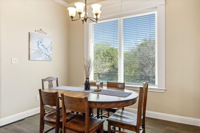 dining space featuring dark wood finished floors, an inviting chandelier, and baseboards