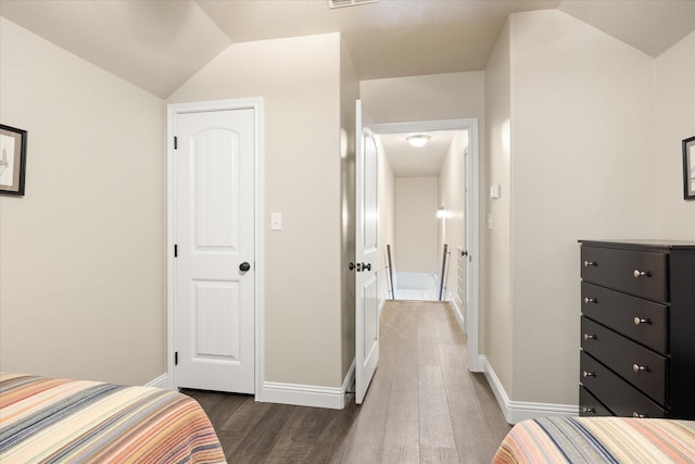 bedroom featuring visible vents, baseboards, lofted ceiling, and dark wood-style floors