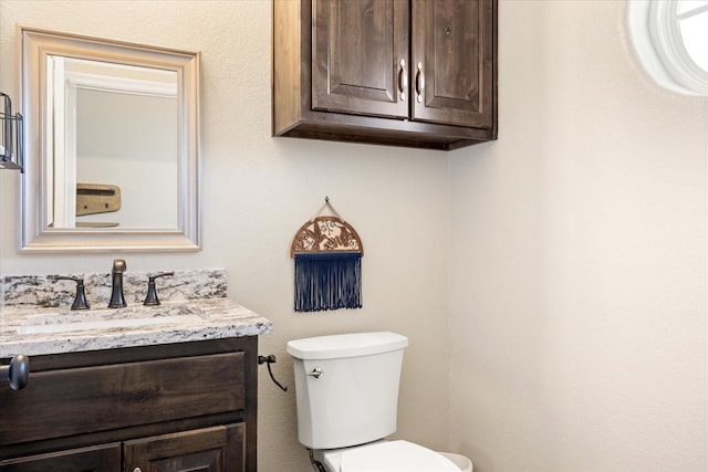 half bath featuring toilet and vanity