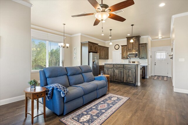 living room with dark wood-type flooring, a healthy amount of sunlight, and crown molding