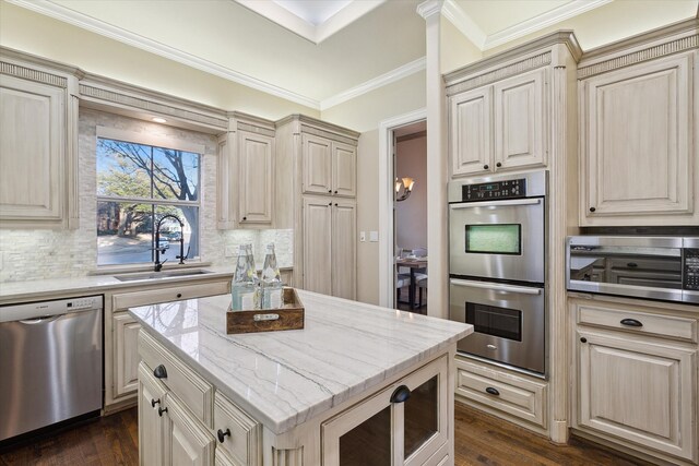 kitchen with decorative backsplash, ornamental molding, appliances with stainless steel finishes, and a sink