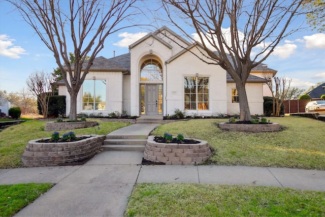 view of front of home featuring brick siding and a front lawn