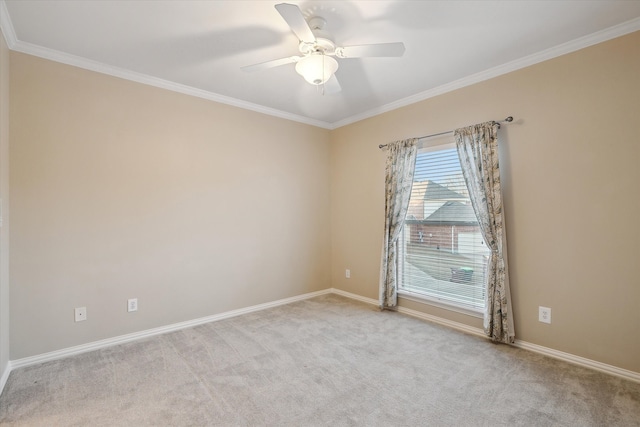 carpeted spare room featuring baseboards, crown molding, and a ceiling fan