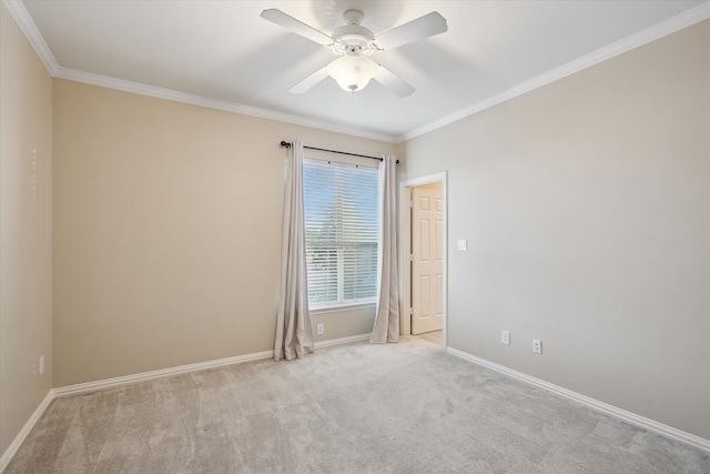 carpeted spare room with ceiling fan, baseboards, and ornamental molding