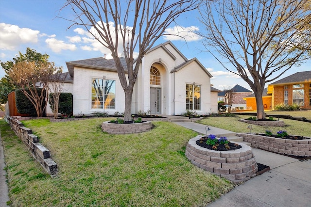 view of front of property with a front lawn and brick siding