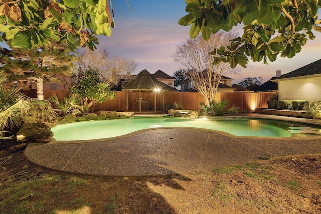 pool at dusk with a fenced in pool, a patio, and a fenced backyard