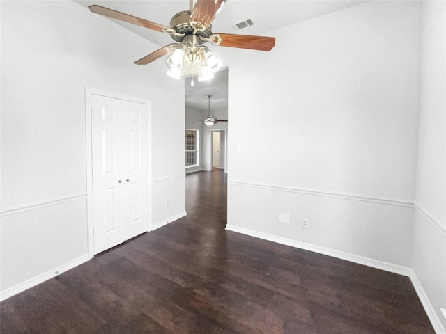 empty room featuring wood finished floors, visible vents, and baseboards