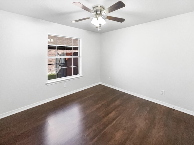 unfurnished room featuring baseboards, dark wood-style flooring, and a ceiling fan