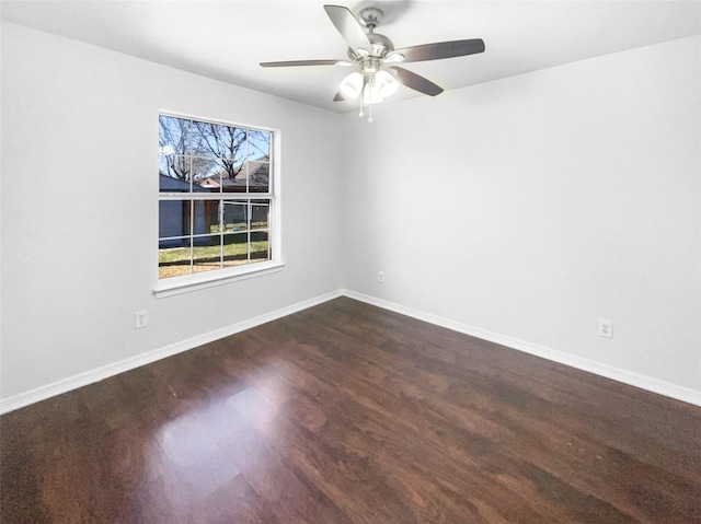 empty room with dark wood finished floors, baseboards, and ceiling fan