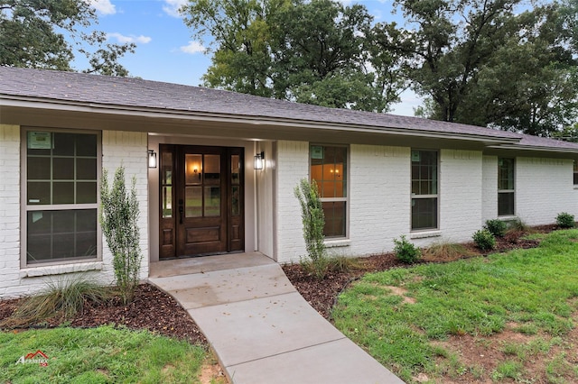 doorway to property featuring brick siding