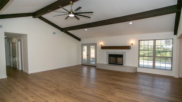 unfurnished living room with wood finished floors, baseboards, visible vents, vaulted ceiling with beams, and a fireplace