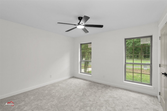 carpeted empty room featuring ceiling fan and baseboards