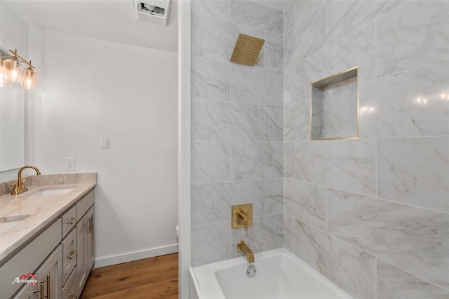 bathroom with baseboards, toilet, double vanity, wood finished floors, and a sink